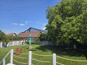 a yard with a white fence and a tree at Casa Deac in Sebeş