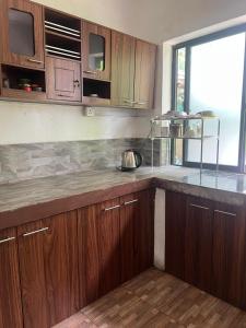 a kitchen with wooden cabinets and a counter top at Floreen villa in Moratuwa