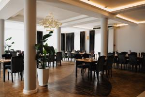 a dining room with tables and chairs and a chandelier at Potocki Dwór in Jędrzejów