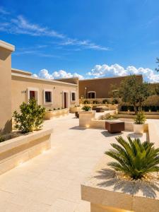 a courtyard of a building with benches and trees at Villa Brigida Resort - Soft Luxury Atmosphere - Adult Oriented in Santeramo in Colle