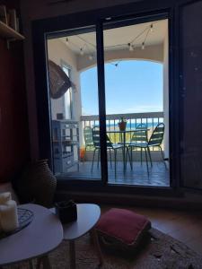 a room with a view of a balcony with a table and chairs at Studio cabine, vue mer, piscine in Saint-Cyprien-Plage