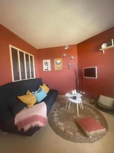 a living room with a couch and a table at Studio cabine, vue mer, piscine in Saint-Cyprien-Plage