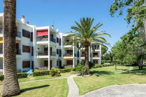 an exterior view of a building with palm trees at Ana Playasol in Port d'Alcudia