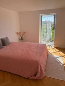 a bedroom with a large bed and a large window at Estate in calm nature in Sorø