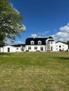 a large white house with a black roof at Estate in calm nature in Sorø
