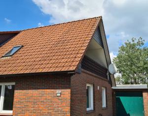 an orange roof on a brick house at Ferienwohnung "Haggi" 35672 in Uplengen