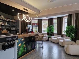 a bar with white chairs and a counter in a room at Avenue Boutique Hotel in Borovoye