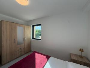 a bedroom with a bed and a mirror and a window at White stone house in Bigova