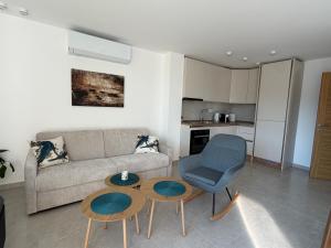a living room with a couch and a table and a chair at White stone house in Bigova