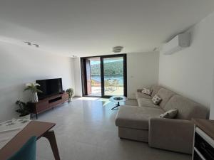 a living room with a couch and a tv at White stone house in Bigova