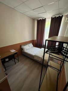a small room with a bed and a window at ABBA Hotel in Kyiv
