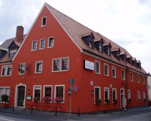 un bâtiment rouge sur le côté d'une rue dans l'établissement Gasthof Weißes Roß, à Kleinostheim