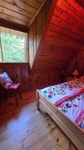 a bedroom with a bed and a chair in a cabin at Chata Koszelanka in Nadkole