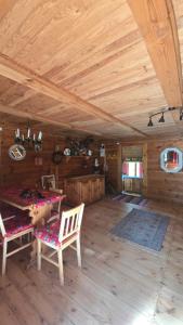 a room with a wooden ceiling with a table and chairs at Chata Koszelanka in Nadkole