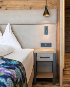 a bedroom with a bed and a nightstand with a lamp at Panorama Alm in Jochberg