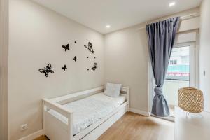 a room with a bed with butterflies on the wall at 2-bedroom Gem Central Odivelas in Odivelas