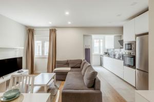 a living room with a couch and a kitchen at 2-bedroom Gem Central Odivelas in Odivelas