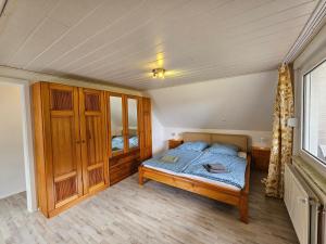 a bedroom with a bed and a wooden cabinet at Ferienwohnung "Haggi" 35672 in Uplengen