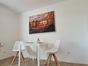 a white table and chairs in a room with a picture on the wall at Ferienwohnung "Haggi" 35672 in Uplengen