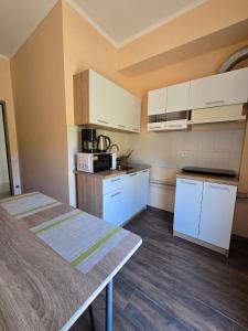 a kitchen with white cabinets and a table in it at ОлександріЯ in Odesa +24 photos