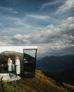 two women standing on top of a mountain with a mirror at Panorama Alm in Jochberg