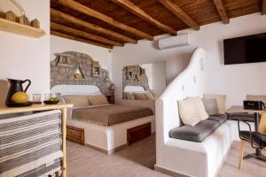a bedroom in a villa with a bed and a desk at Infinito Boathouse Milos in Agia Irini Milos