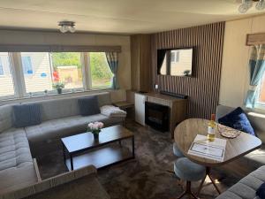 a living room with a couch and a table at Elite Retreat Caravan in Blackpool