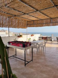 a ping pong table on a patio with a view of the beach at Atlantic view Tamraght 3 in Tamraght Ou Fella