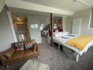 a bedroom with a bed and a couch at Hope Corner in Filey