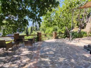 a patio with chairs and tables and a fence at Cortijo De Los Abuelos in Pampaneira