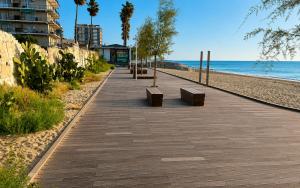 a boardwalk on the beach next to the ocean at Sea View Apartment - Private Parking AC in Savona