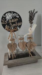 a wooden tray with three glass jars and a vase at L'Orée des Vignes 41 - Chambres d'hôtes in Saint-Georges-sur-Cher