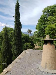 a tree and a stone wall with a tower at Cortijo De Los Abuelos in Pampaneira