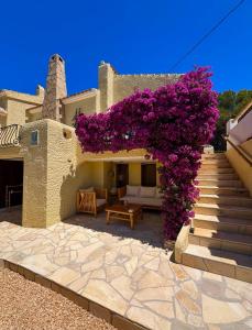 a house with purple flowers on the side of it at Villa Mirella in Jávea