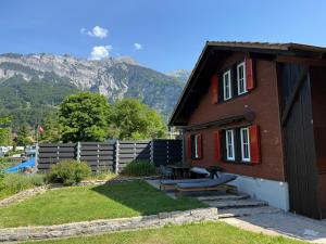 a red brick house with a picnic table in the yard at Beachhouse 16 Brienzersee in Brienz