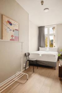 a bedroom with a bed and a chair and a window at Bergen Guesthouse in Bergen