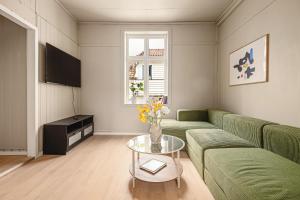 a living room with a green couch and a table at Bergen Guesthouse in Bergen