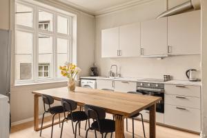 a kitchen with a wooden table and black chairs at Bergen Guesthouse in Bergen