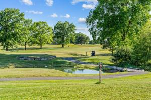 a golf course with a pond and trees at Austin's Hideaway Golf-view in Branson