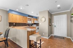a kitchen with wooden cabinets and a bar with a table at Austin's Hideaway Golf-view in Branson