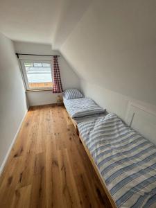 an attic bedroom with two beds and a window at Schlosserhäuschen in Leipzig