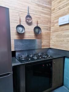 a kitchen with a stove with pots and pans on the wall at De Oude Schuur in Stellenbosch