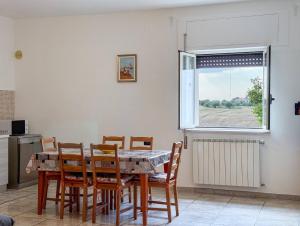 a dining room with a table and chairs and a window at Allombra della quercia in Ortona