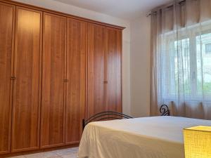 a bedroom with a bed and wooden cabinets at Allombra della quercia in Ortona