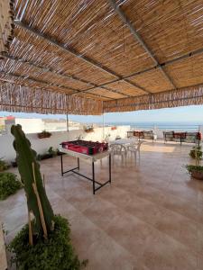 a pavilion with a table and chairs and the ocean at Atlantic view Tamraght 1 in Tamraght Ou Fella
