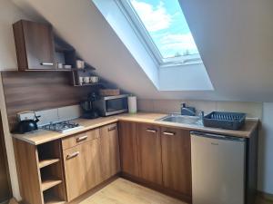 a kitchen with a sink and a skylight at Domki Wichrowe Wzgórze Bieszczady in Bukowiec +23 photos