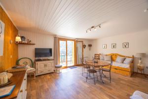 a living room with a couch and a table at L'Edelweiss - Bouvier in Aillon-le-Jeune