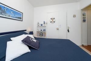 a bedroom with a blue bed with two pillows on it at Couette et café in Arradon