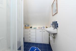 a white bathroom with a sink and a mirror at Couette et café in Arradon