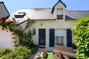 a house with a blue door and a bench at Couette et café in Arradon